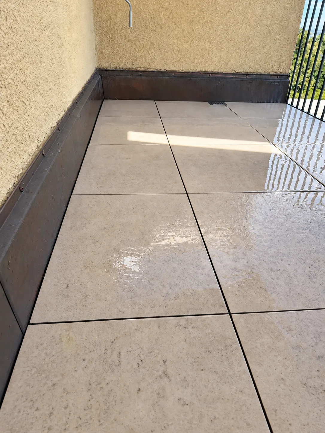 Dalles de balcon propres et partie métallique à gauche nettoyée.