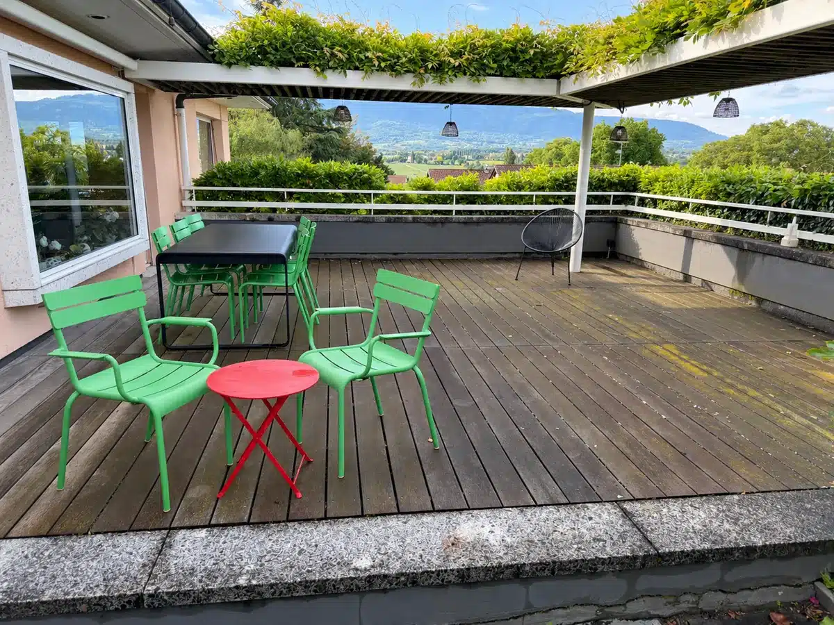 Terrasse en bois sous une pergola avant nettoyage.